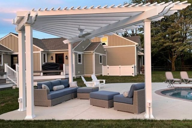 free standing vinyl pergola with posts over an outdoor furniture set beside an outdoor pool