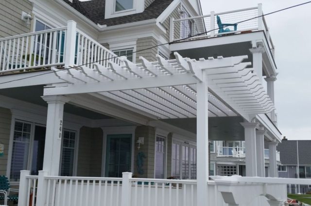 view of the white vinyl pergola and patio railings, highlighting the beach condo's inviting and stylish outdoor space.