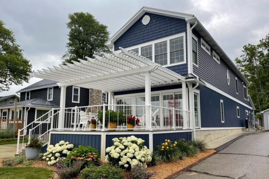 white pergola built by custom pergola experts on blue house