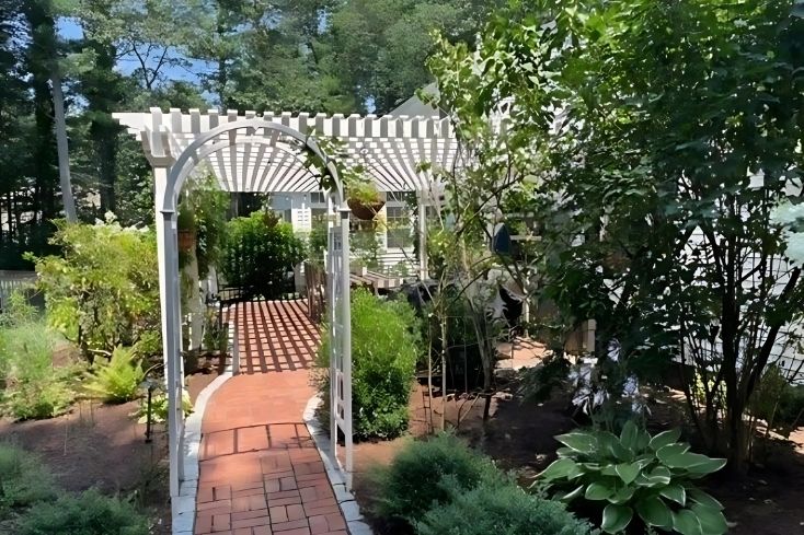 difference between arbor and pergola showing pat with both white vinyl structures